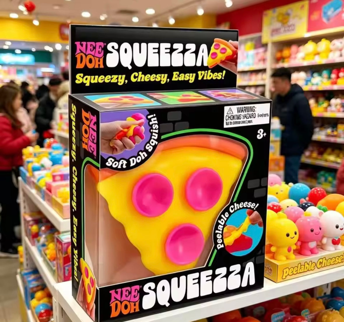 NeeDoh Squeezza pizza fidget toy on toy store shelf showing Peelable Cheese feature by Schylling