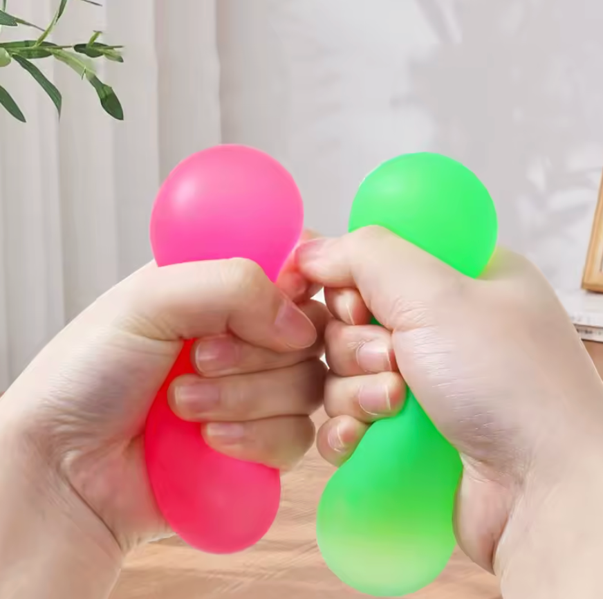 Adult hand holding NeeDoh Super Groovy Glob showing jumbo palm-filling size versus classic NeeDoh ball
